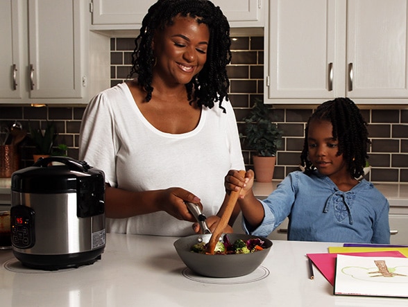 A mother and daughter cooking with Ki Cordless Kitchen appliances